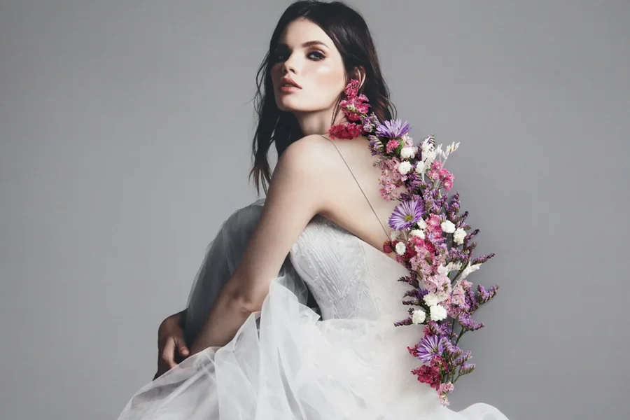Bride sitting in dress with flowers growing from their spine