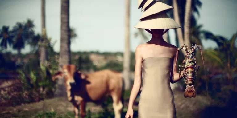 Corps féminin vêtu d'une tenue surréaliste tenant un homard dans un champ