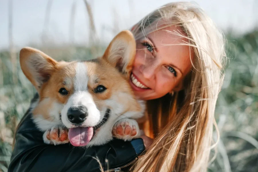 Happy Woman Holding a Smiling Corgi
