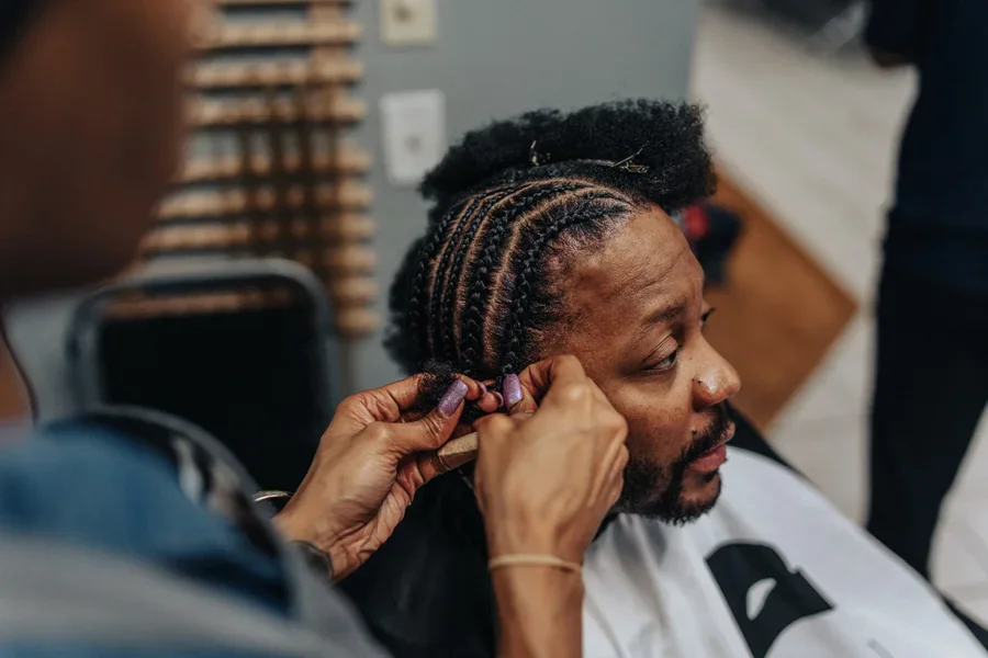 Man Having Hair Braided In Barber Shop