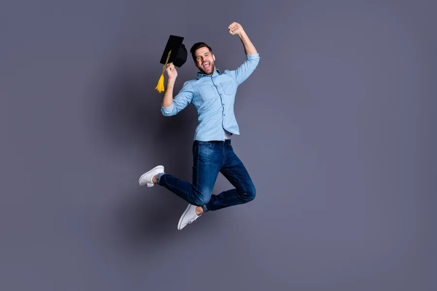 Hombre sosteniendo un birrete de graduación para fotos divertidas antes de la ceremonia