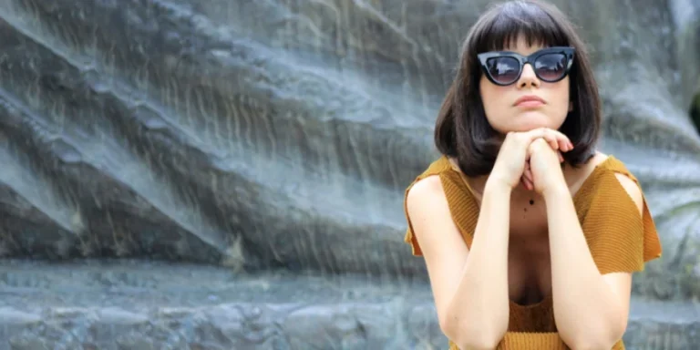 Frau mit mittellangem Haar und Sonnenbrille