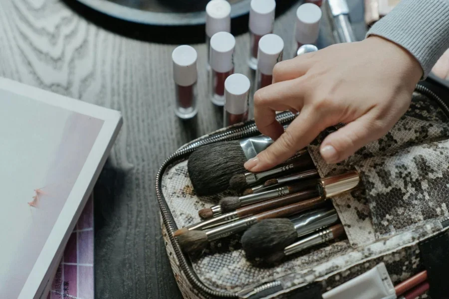 Person Holding White and Brown Makeup Brush Set
