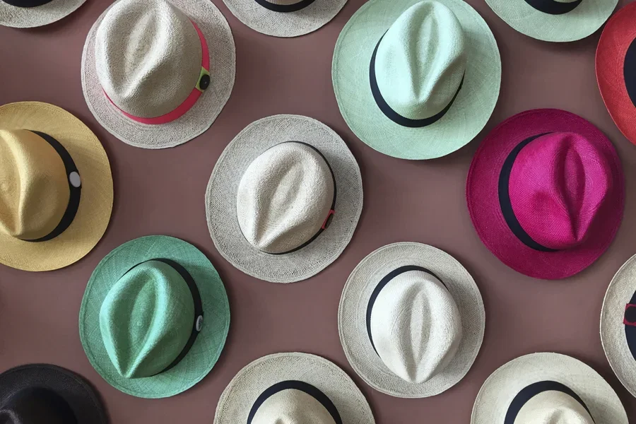 Selección de sombreros de paja en diferentes colores en la pared.