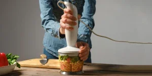Unrecognizable woman preparing salsa or guacamole in a blender