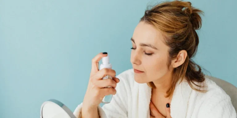 顔に製品をスプレーする女性