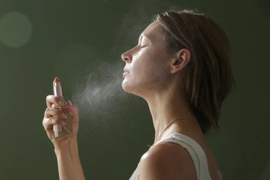 Femme se vaporisant une brume pour le visage, concept de soin de la peau estival