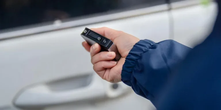 Женщина использует дистанционный ключ, чтобы открыть дверь автомобиля.