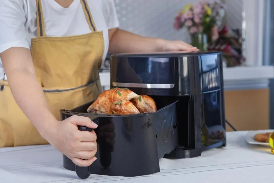 Mujer usando freidora de aire en la cocina