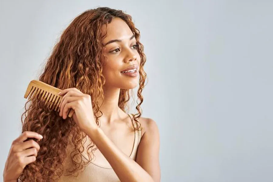 Young Female Combing Her Beautiful Curls
