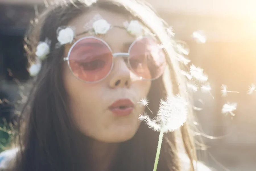 Young Hippie Woman Blowing Dandelion