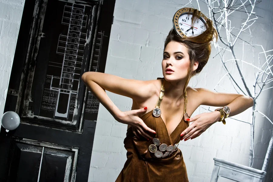 Young artist in haute couture collection with clock in hair
