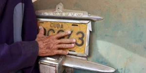 La main d'un homme âgé touche la plaque d'immatriculation d'une voiture