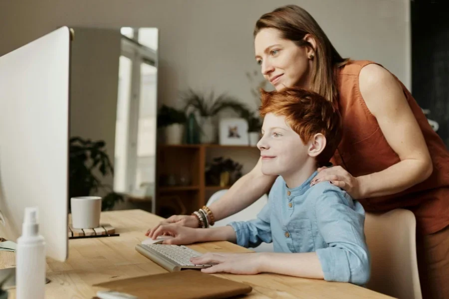 Foto einer lächelnden Frau, die ihrem Sohn etwas beibringt.