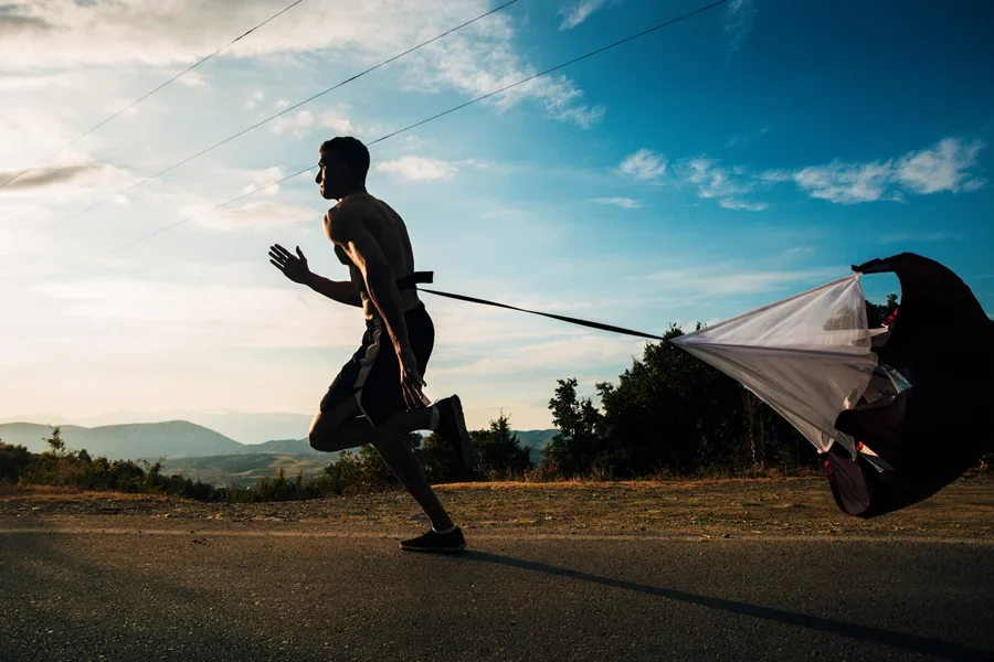 Sportive Guy Running Fast While Carrying Sport Parachute
