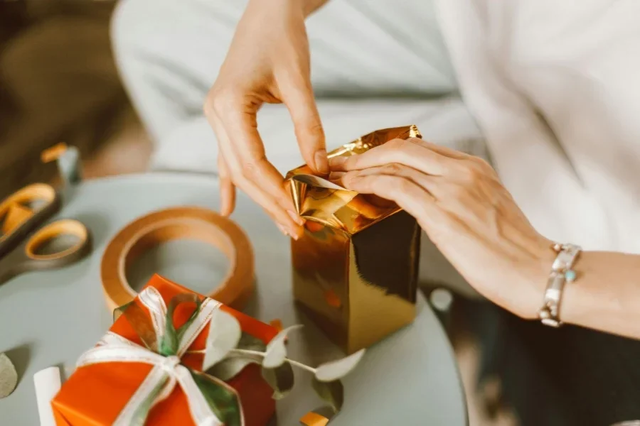 Femme emballant des boîtes cadeaux